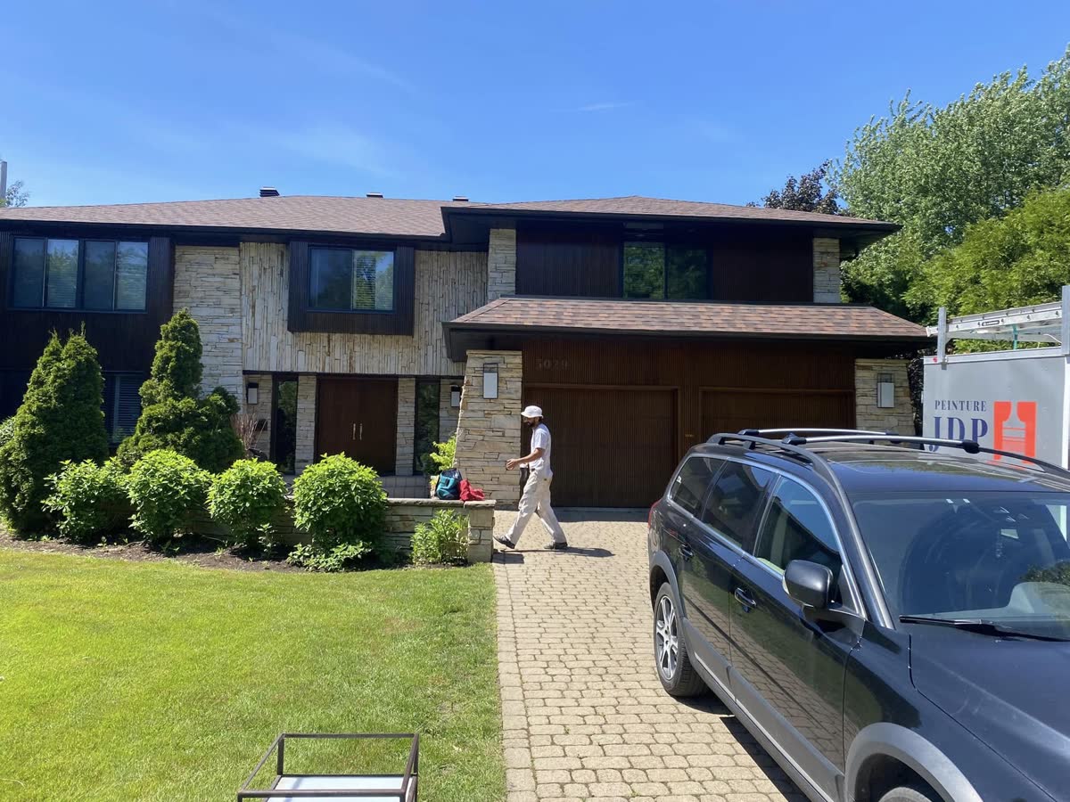 Peintre de JDP dans l'entrée d'une maison, la remorque JDP derrière